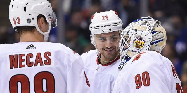 Carolina Hurricanes right wing Nino Niederreiter (21) and center Martin Necas (88) speak to Hurricanes emergency goalie David Ayres as he takes the ice against the Toronto Maple Leafs during second-period NHL hockey game action in Toronto, Saturday, Feb. 22, 2020. (Frank Gunn/The Canadian Press via AP)