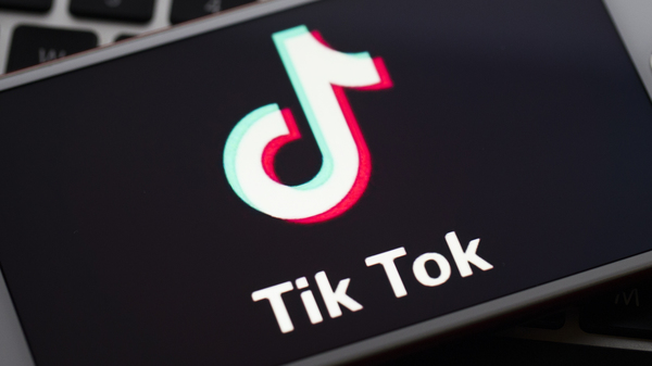 In this photo illustration a mobile phone screen displays TikTok logo in front of a keyboard.