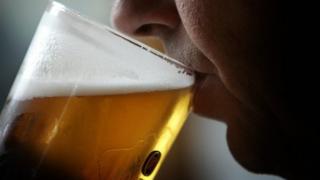 Man drinking pint of lager