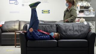 Ikea shopper on his back on sofa
