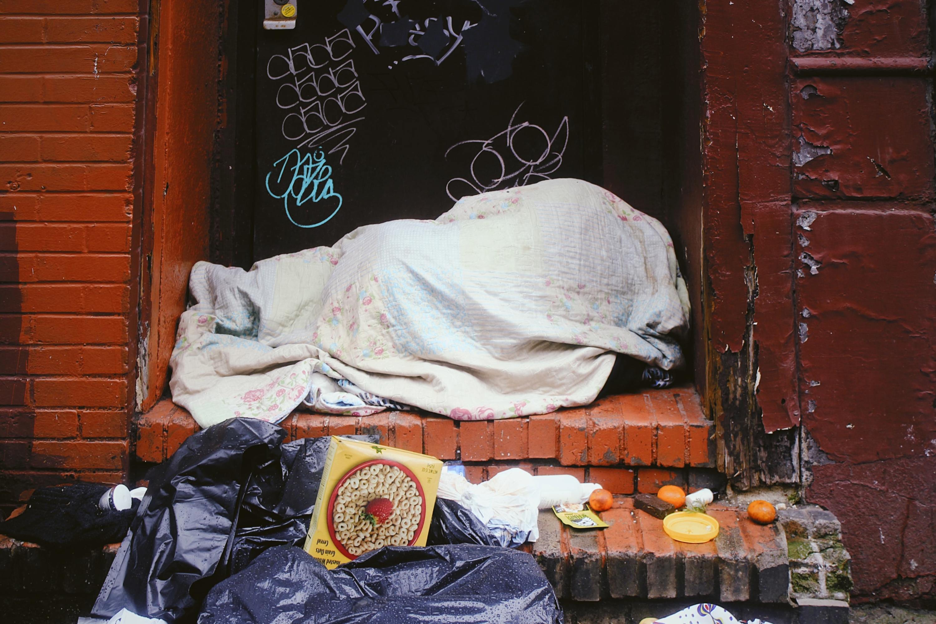 A homeless person bundled up on the street.