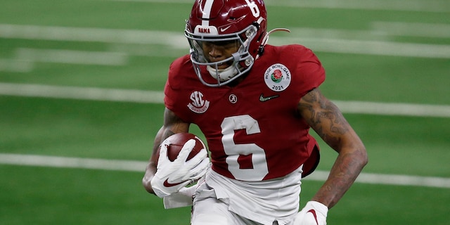 Alabama wide receiver DeVonta Smith (6) gains yardage after a catch in the first half of the Rose Bowl NCAA college football game against Notre Dame in Arlington, Texas, Friday, Jan. 1, 2021. (AP Photo/Roger Steinman)