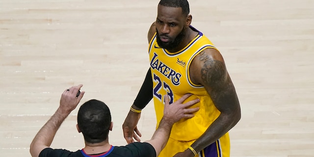 Los Angeles Lakers forward LeBron James (23) is restrained by an official as he reacts to a fan in the second half of an NBA basketball game against the Atlanta Hawks, Monday, Feb. 1, 2021, in Atlanta. (AP Photo/John Bazemore)
