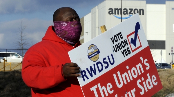 Michael Foster of the Retail, Wholesale and Department Store Union holds a sign outside an Amazon warehouse in Bessemer, Ala., where workers are voting on whether to unionize.