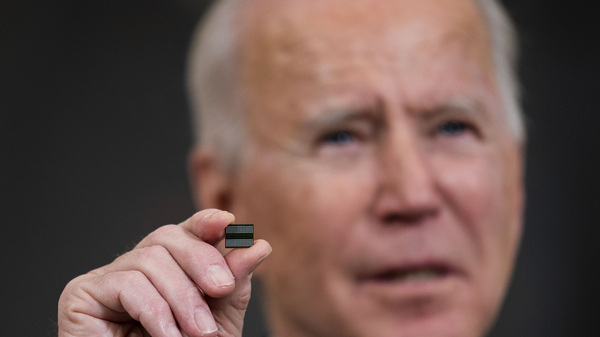 President Biden holds a semiconductor during remarks before signing an executive order on the economy at the White House on Feb. 24. On Monday, senior members of his team met with leaders across various industries to discuss a shortage of semiconductors.