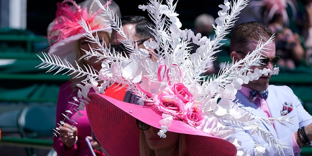 A women watches a race before the 147th running of the Kentucky Oaks at Churchill Downs, Friday, April 30, 2021, in Louisville, Ky.(AP Photo/Michael Conroy)