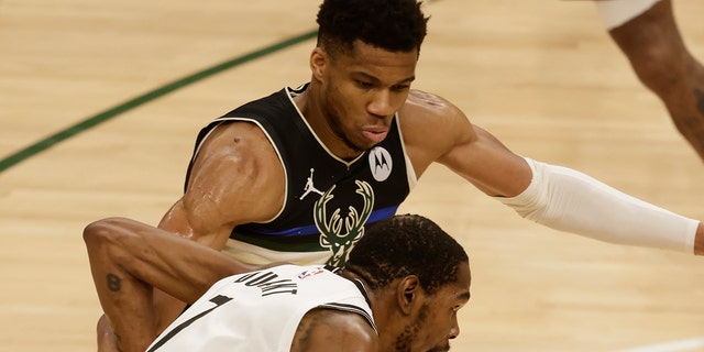 Milwaukee Bucks forward Giannis Antetokounmpo, top, guards against Brooklyn Nets' Kevin Durant during the second half of Game 6 of a second-round NBA basketball playoff series Thursday, June 17, 2021, in Milwaukee. (AP Photo/Jeffrey Phelps)