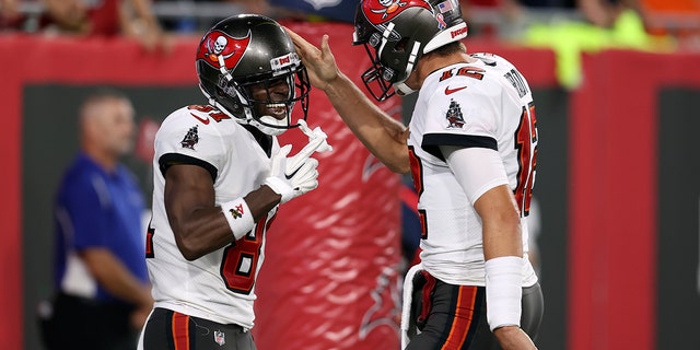 Tampa Bay Buccaneers quarterback Tom Brady (12) celebrates with wide receiver Antonio Brown (81) after Brown caught a touchdown pass against the Dallas Cowboys during the first half of an NFL football game Thursday, Sept. 9, 2021, in Tampa, Fla. (AP Photo/Mark LoMoglio)