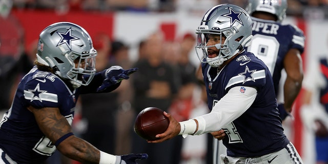 Dallas Cowboys quarterback Dak Prescott (4) hands off to running back Ezekiel Elliott (21) during the first half of an NFL football game against the Tampa Bay Buccaneers Thursday, Sept. 9, 2021, in Tampa, Fla. (AP Photo/Scott Audette)