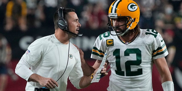 Green Bay Packers head coach Matt LaFleur talks with quarterback Aaron Rodgers (12) during the first half of an NFL football game against the Arizona Cardinals, Thursday, Oct. 28, 2021, in Glendale, Ariz.