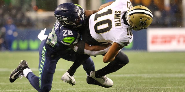 SEATTLE, WASHINGTON - OCTOBER 25: Tre'Quan Smith #10 of the New Orleans Saints is brought down by Ugo Amadi #28 of the Seattle Seahawks during the second half at Lumen Field on October 25, 2021 in Seattle, Washington.