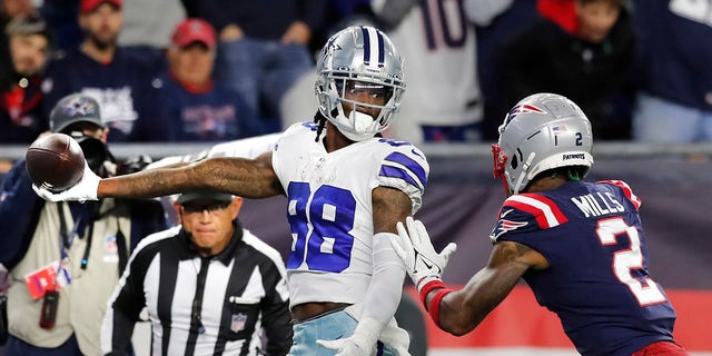 Dallas Cowboys wide receiver CeeDee Lamb (88) stretches the ball over the goal line for the game-winning touchdown as New England Patriots cornerback Jalen Mills (2) gives chase Sunday, Oct. 17, 2021, in Foxborough, Mass.