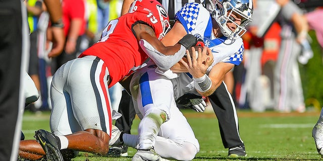 Georgia linebacker Adam Anderson (19) tackles Kentucky quarterback Will Levis (7) during the college football game between the Kentucky Wildcats and the Georgia Bulldogs on Oct. 16, 2021, at Sanford Stadium in Athens, Georgia. 