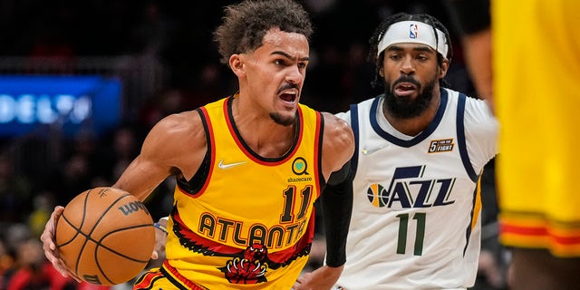 Atlanta Hawks guard Trae Young (11) dribbles past Utah Jazz guard Mike Conley (11) during the first quarter Nov. 4, 2021, at State Farm Arena in Atlanta, Ga.