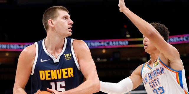 Oct 13, 2021; Oklahoma City, Oklahoma, USA; Denver Nuggets center Nikola Jokic (15) is guarded by Oklahoma City Thunder center Isaiah Roby (22) on a drive to the basket during the first quarter at Paycom Center.