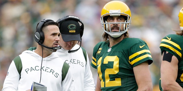 Aaron Rodgers #12 talks with Green Bay Packers head coach Matt LaFleur during the game against the Washington Football Team at Lambeau Field on October 24, 2021 in Green Bay, Wisconsin. Green Bay defeated Washington 24-10.