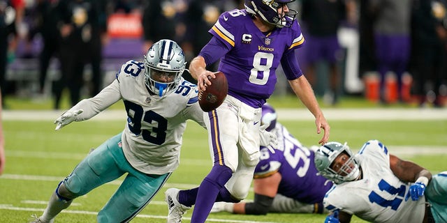 Minnesota Vikings quarterback Kirk Cousins (8) runs from Dallas Cowboys defensive end Tarell Basham (93) during the second half of an NFL football game, Sunday, Oct. 31, 2021, in Minneapolis. The Cowboys won 20-16.
