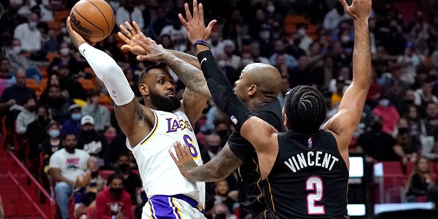 Los Angeles Lakers forward LeBron James (6) attempts to pass the ball as Miami Heat forward P.J. Tucker, center, and guard Gabe Vincent (2) defend during the first half of an NBA basketball game, Sunday, Jan. 23, 2022, in Miami.