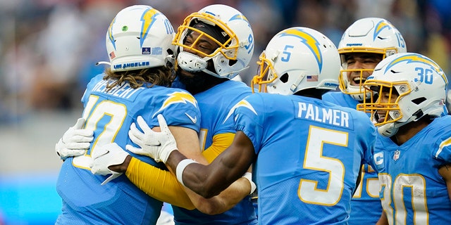 Los Angeles Chargers quarterback Justin Herbert (10) hugs wide receiver Mike Williams after Williams' touchdown catch during the second half of an NFL football game against the Denver Broncos Sunday, Jan. 2, 2022, in Inglewood, California.
