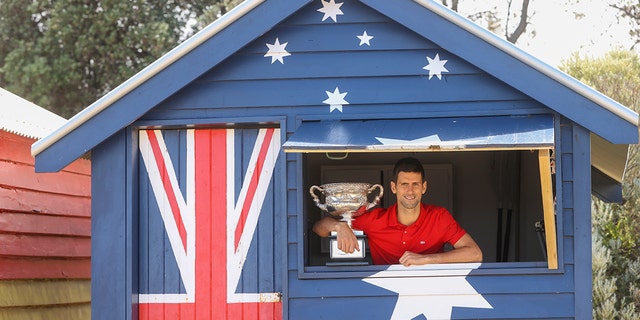Serbia's Novak Djokovic poses with the Norman Brookes Challenge Cup the day after defeating Russia's Daniil Medvedev in the men's singles final at the Australian Open tennis championship in Melbourne, Australia, Monday, Feb. 22, 2021.