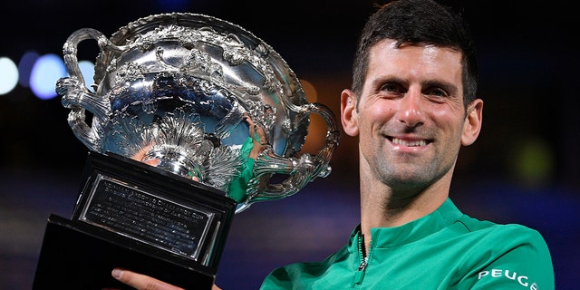 Serbia's Novak Djokovic holds the Norman Brookes Challenge Cup after defeating Russia's Daniil Medvedev in the men's singles final at the Australian Open tennis championship in Melbourne, Australia, Sunday, Feb. 21, 2021.