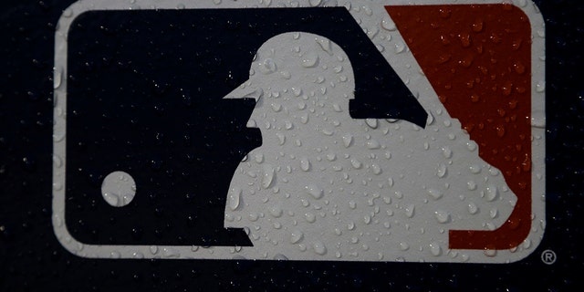 FILE - A rain-covered logo is seen at Fenway Park before Game 1 of the World Series baseball game between the Boston Red Sox and the Los Angeles Dodgers Tuesday, Oct. 23, 2018, in Boston. The mood for Major League Baseball fans is a little glum these days as the players' union and owners continue to bicker over finances. The owners locked out the players on Dec. 2 and unless an agreement between the two sides is reached soon, the spring training schedule is in trouble. The first games are slated for Feb. 26, 2022.