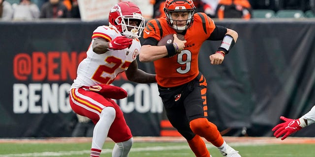 Cincinnati Bengals quarterback Joe Burrow (9) scrambles against Kansas City Chiefs cornerback Rashad Fenton (27) during the first half of an NFL football game, Sunday, Jan. 2, 2022, in Cincinnati.