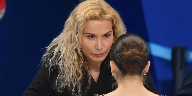 Kamila Valieva of Team ROC talks to coaches Eteri Tutberidze (L) and Sergei Dudakov (R) during the Women Single Skating Free Skating on day thirteen of the Beijing 2022 Winter Olympic Games at Capital Indoor Stadium on Feb. 17, 2022 in Beijing, China.