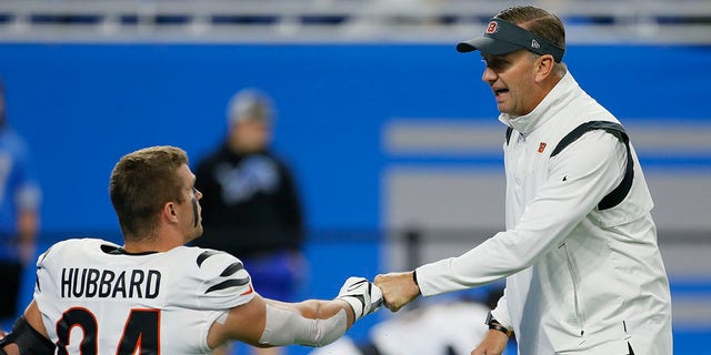 FILE - Cincinnati Bengals special team coordinator Darrin Simmons fist-bumps defensive end Sam Hubbard before the team's NFL football game against the Detroit Lions on Oct. 17, 2021, in Detroit. Simmons arrived with the team in 2003 and has been a model of stability. He has had the same punter/holder and long snapper since 2009, which also helped in the development of kicker Evan McPherson.
