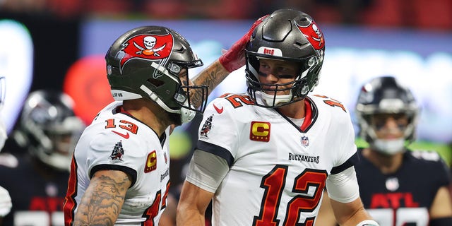 Tom Brady of the Tampa Bay Buccaneers celebrates with Mike Evans after a touchdown pass against the Falcons at Mercedes-Benz Stadium on Dec. 5, 2021, in Atlanta, Georgia.