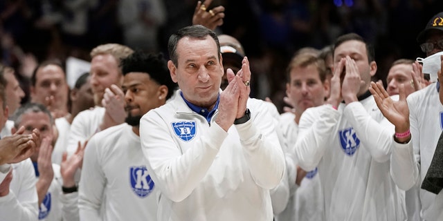 Surrounded by former players, Duke coach Mike Krzyzewski applauds while being recognized prior to the team's NCAA college basketball game against North Carolina in Durham, N.C., Saturday, March 5, 2022. The matchup is Krzyzewski's final game at Cameron Indoor Stadium.