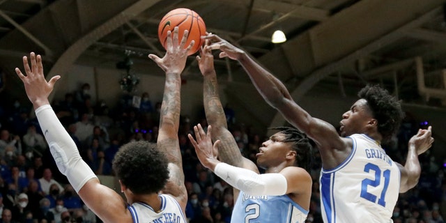 North Carolina guard Caleb Love (2) shoots against Duke forward Paolo Banchero (5) and forward AJ Griffin (21) during the first half of an NCAA college basketball game Saturday, March 5, 2022, in Durham, N.C. (Associated Press)