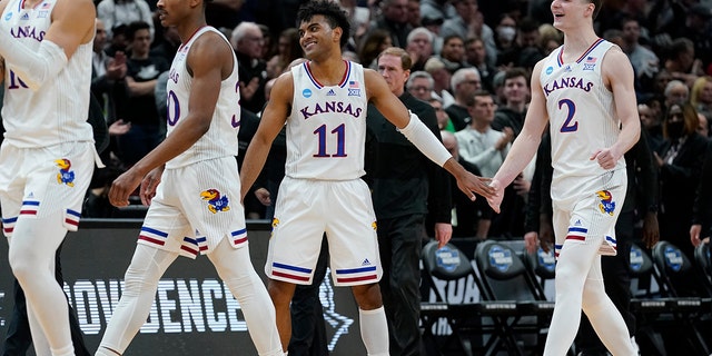 Kansas' Remy Martin and Christian Braun celebrate after the second half of a college basketball game in the Sweet 16 round of the NCAA tournament against Providence Friday, March 25, 2022, in Chicago. Kansas won 66-61.