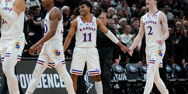 Kansas' Remy Martin and Christian Braun celebrate after the second half of a college basketball game in the Sweet 16 round of the NCAA tournament against Providence Friday, March 25, 2022, in Chicago. Kansas won 66-61.