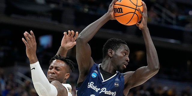 Saint Peter's Hassan Drame (14) grabs a rebound against Murray State's Trae Hannibal, left, during the first half of a college basketball game in the second round of the NCAA tournament, Saturday, March 19, 2022, in Indianapolis. 