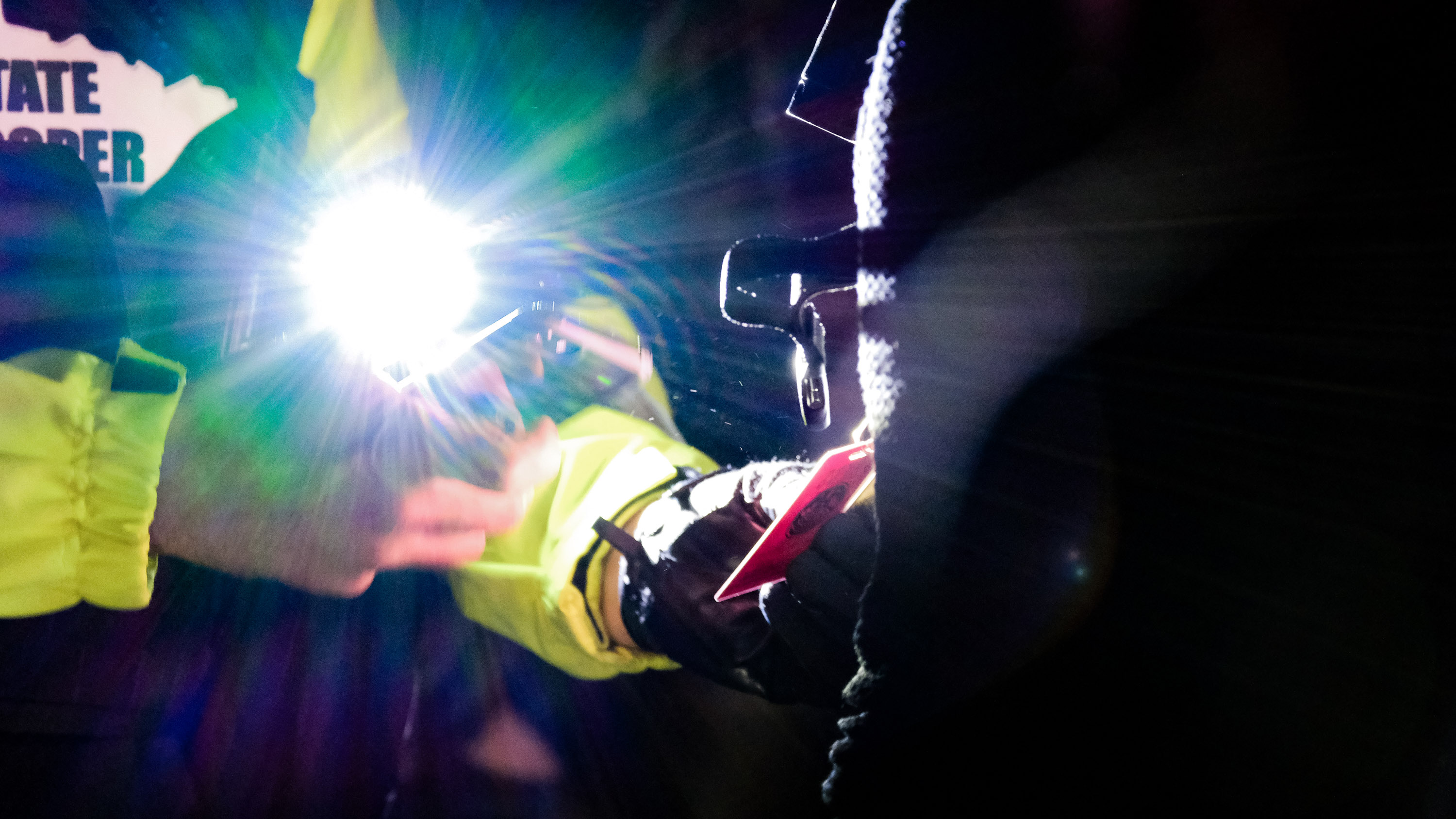 police officer uses cell phone to capture a journalist's badge