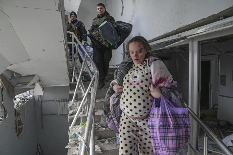 Image: An injured pregnant woman walks downstairs in the maternity hospital damaged by shelling in Mariupol, Ukraine, on March 9, 2022.