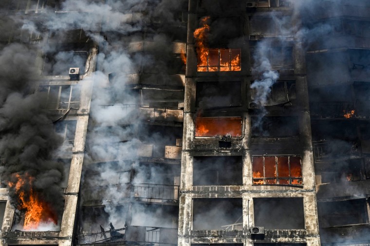 Firefighters work to extinguish a fire in an apartment building in Kyiv on March 15, 2022.