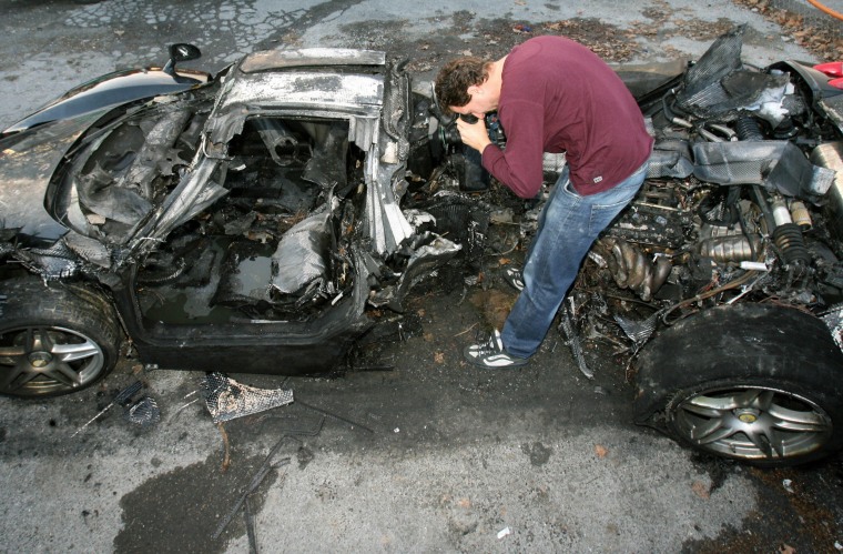 A journalist films the wreck of a black