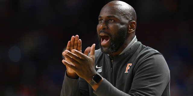 Head coach Dedrique Taylor of the Cal State Fullerton Titans cheers on his team against the Duke Blue Devils during the first round of the 2022 NCAA Men's Basketball Tournament held at Bon Secours Wellness Arena on March 18, 2022 in Greenville, South Carolina.