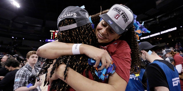 Stanford guard Haley Jones, right, wears a Final Four ball cap as she hugs forward Francesca Belibi, left, after a college basketball game against Texas in the Elite 8 round of the NCAA tournament, Sunday, March 27, 2022, in Spokane, Wash. Stanford won 59-50.