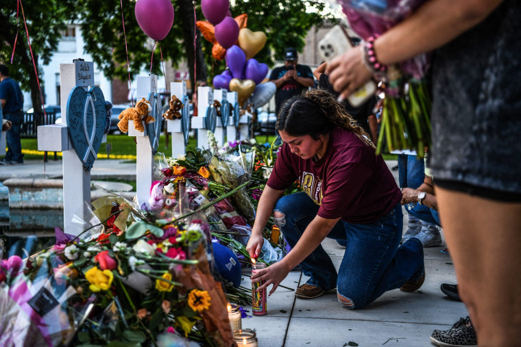 Image: A woman lights a candle at a makeshift memorial outside Uvalde County Courthouse in Uvalde, Texas, on May 26, 2022.