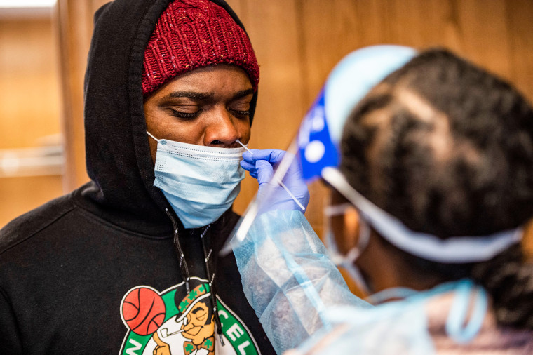 Image: A medical worker performs a PCR test for Covid-19 in Boston on December 20, 2021.