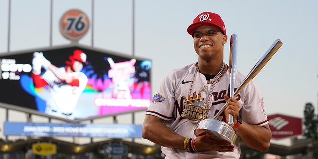 National League's Juan Soto of the Washington Nationals holds the winner's trophy after the MLB Home Run Derby, July 18, 2022, in Los Angeles.