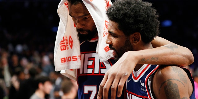 Kevin Durant and Kyrie Irving of the Nets talk during the Cleveland Cavaliers game at Barclays Center on April 8, 2022, in Brooklyn. 