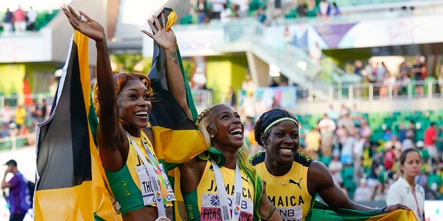 Gold medalist Shelly-Ann Fraser-Pryce, of Jamaica, center, stands with silver medalist Shericka Jackson, of Jamaica, right, and bronze medalist Elaine Thompson-Herah, of Jamaica, wave after a medal ceremony for the final in the women's 100-meter run at the World Athletics Championships on Sunday, July 17, 2022, in Eugene, Ore. (AP Photo/Ashley Landis)