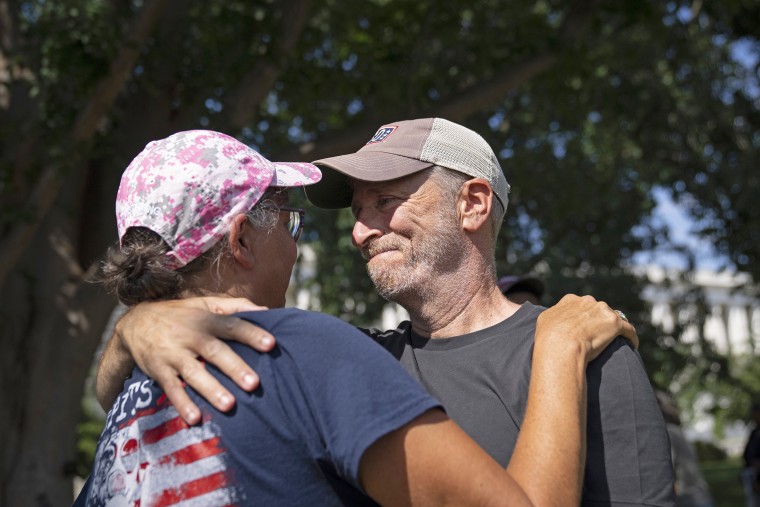Image: Comedian and activist Jon Stewart embraces Susan Zeier, mother-in-law of the late Sgt. First Class Heath Robinson, before the Senate vote on the PACT Act outside the Capitol on Aug. 2, 2022.