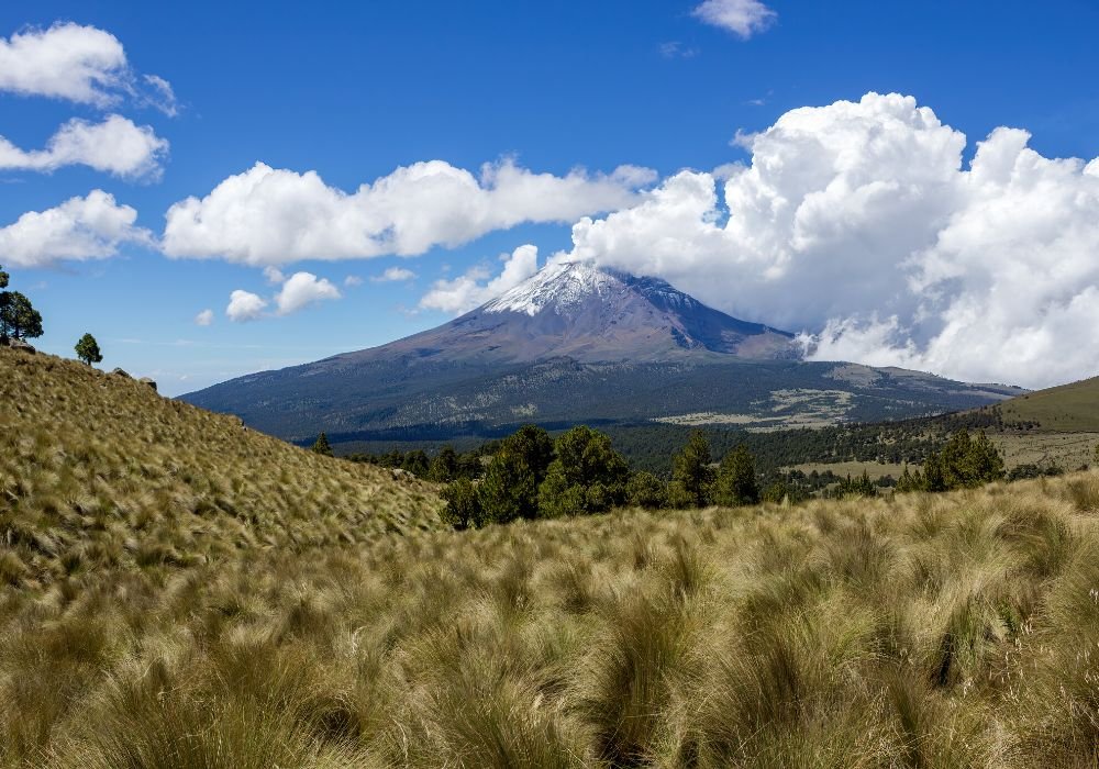 The beautiful Iztaccihuatl-Popocatepetl National Park with a blue sky and clouds on the background.