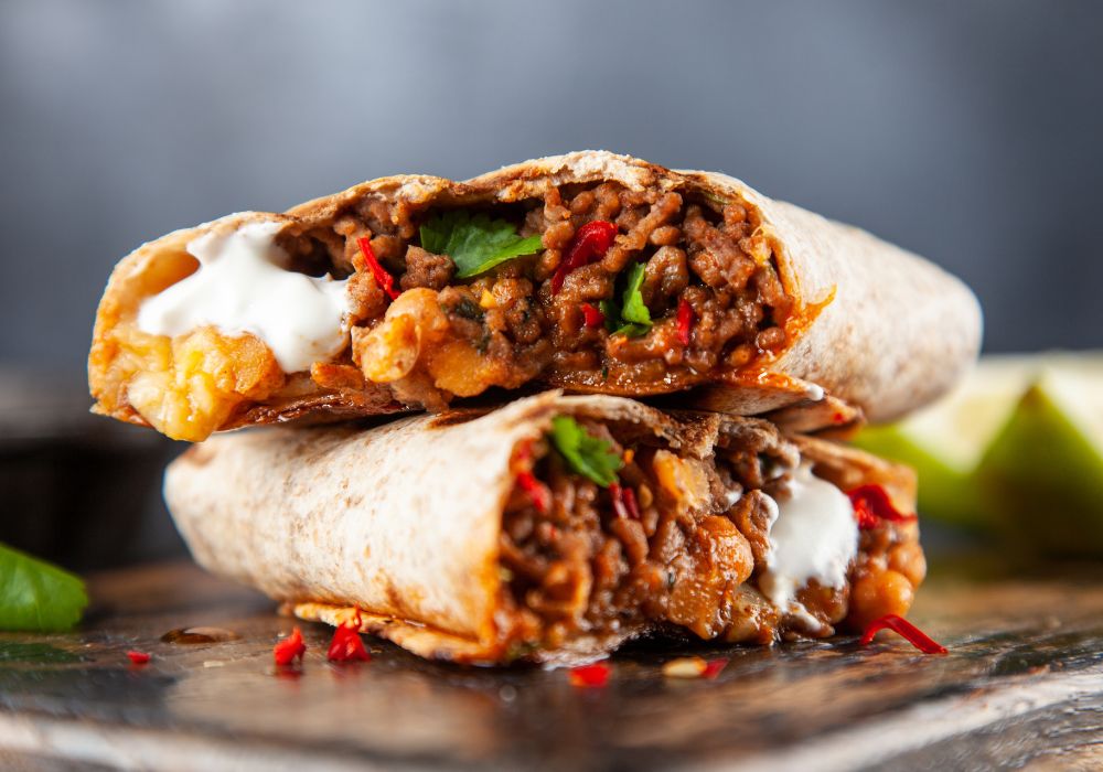 A closer look at the Mexican beef burrito on a wooden board.
