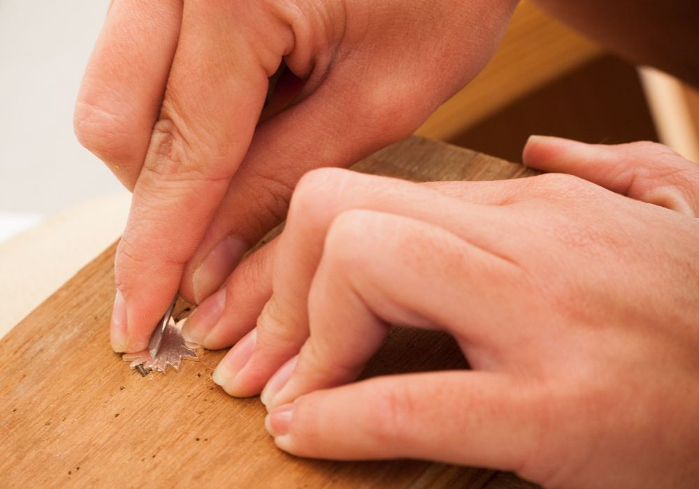 A woman makes a silver ring during a workshop.